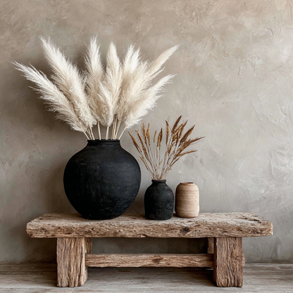 Kunstwerk Adem van Steen met donkere vaas, pluimen en houten tafel in neutrale aardetinten.
