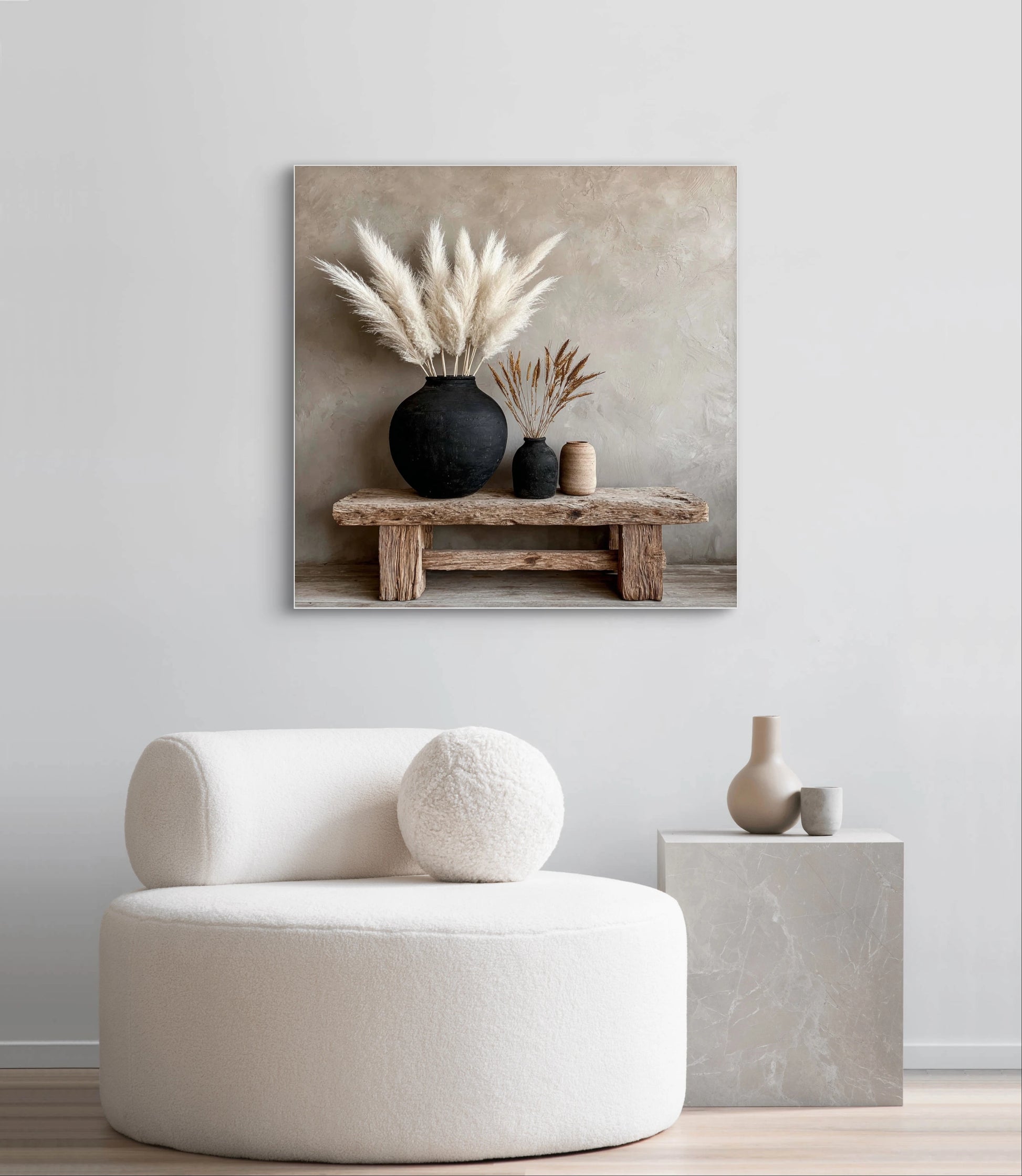 Textielkunstwerk Adem van Steen aan een lichte wand boven een ronde witte fauteuil met minimalistische decoratie.
