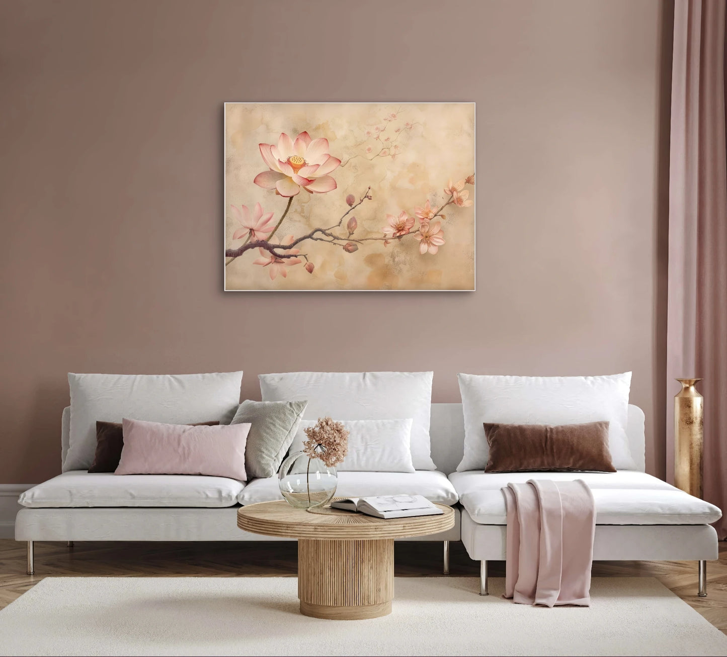 Textielkunstwerk met bloesemtakken in zachte roze en goudtinten, hangend boven witte bank in warmroze interieur
