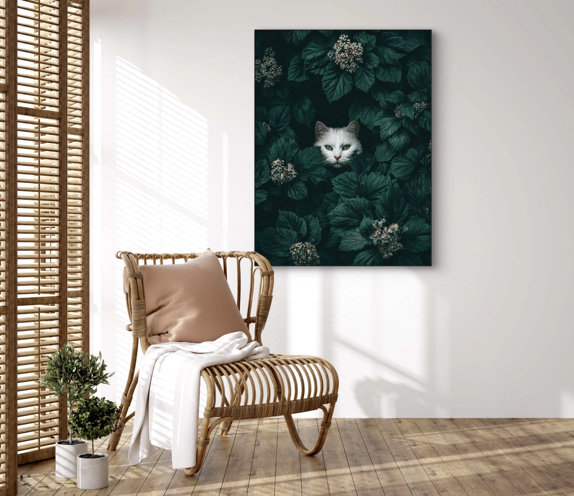 Bladsluier kunstwerk aan de muur boven rotanstoel met kussen  
