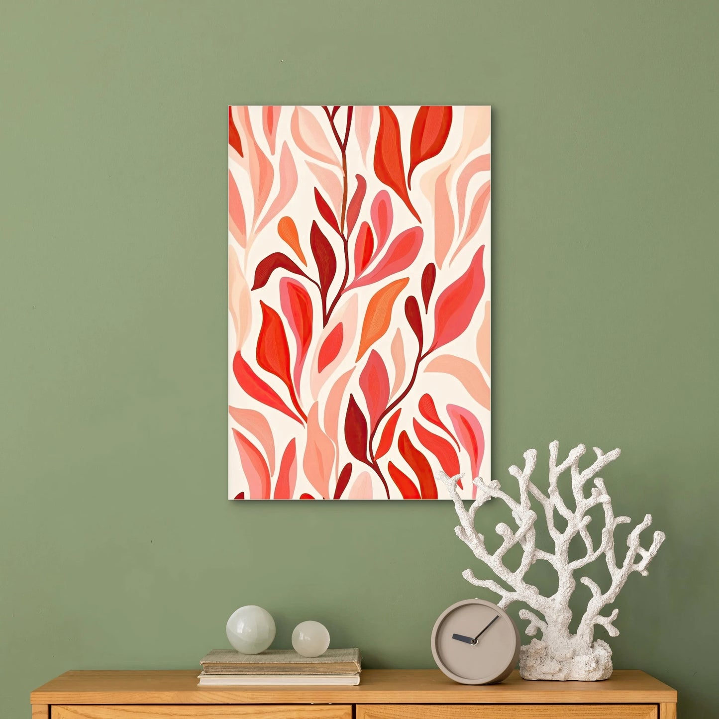 Moderne wanddecoratie met blad- en bloemvormen in rood, roze en perziktinten op licht textiel
