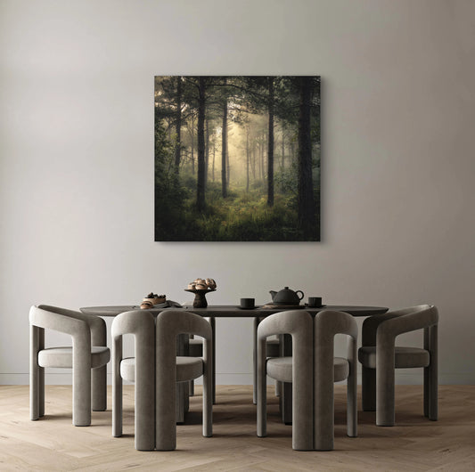 Boslandschap met lichtinval tussen bomen aan de muur in een modern interieur met grijze stoelen en houten vloer
