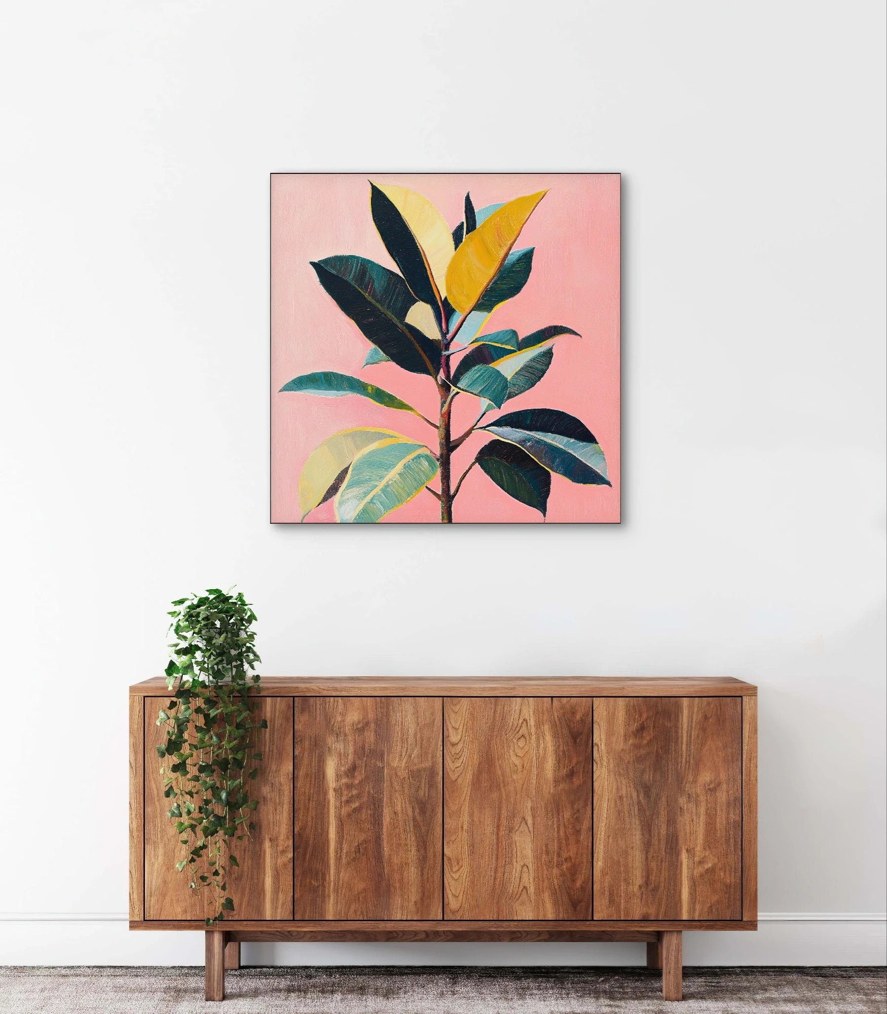 Textielkunstwerk met kleurrijke plant en roze achtergrond, hangend boven houten kast in licht interieur
