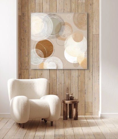 Abstract kunstwerk in beige, wit en bruintinten boven houten wand met lichte fauteuil
