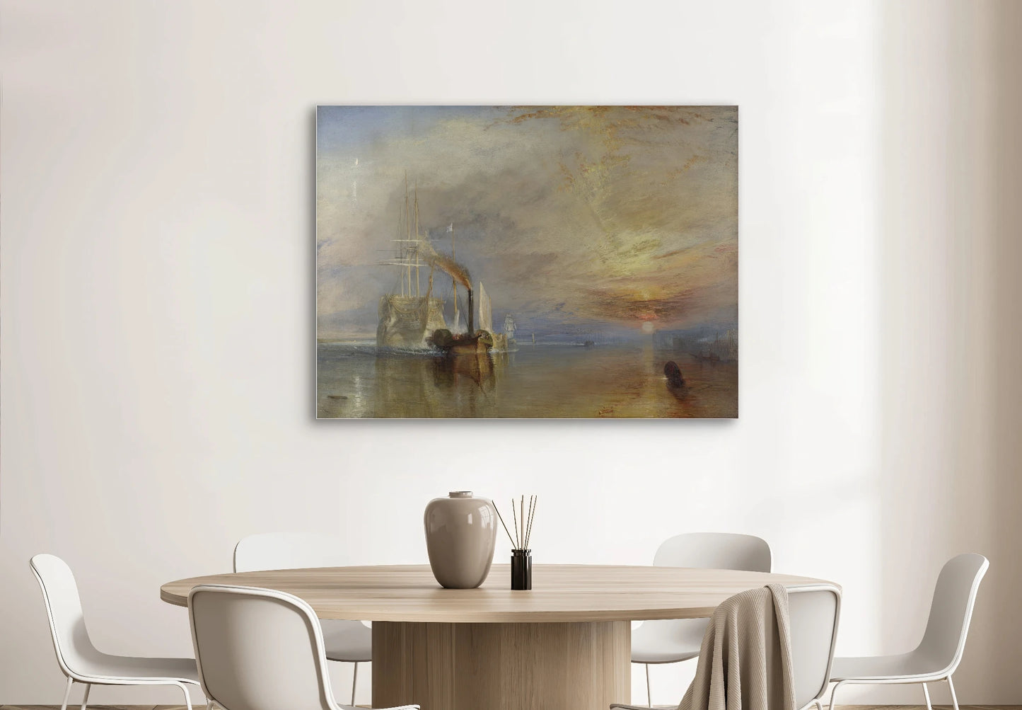 Schilderij “De Vechtende Temeraire” van Turner boven een ronde houten eettafel met witte stoelen
