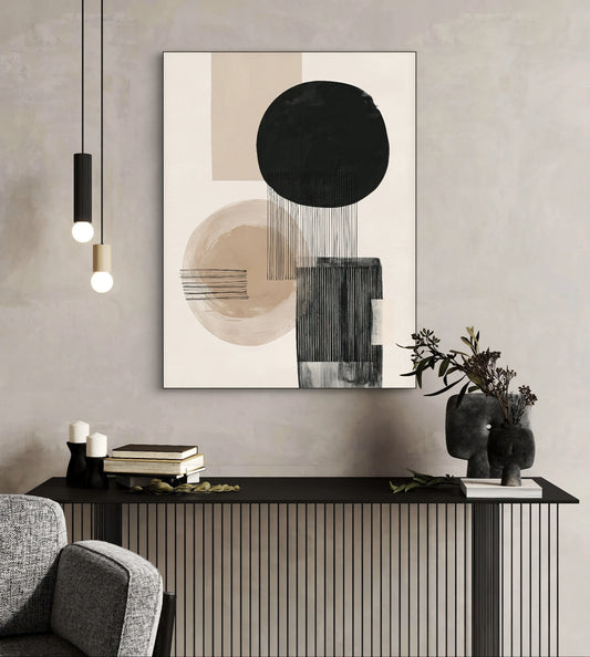 Textielkunstwerk met abstracte vormen in beige, zwart en grijs, hangend boven een zwart dressoir in een modern interieur
