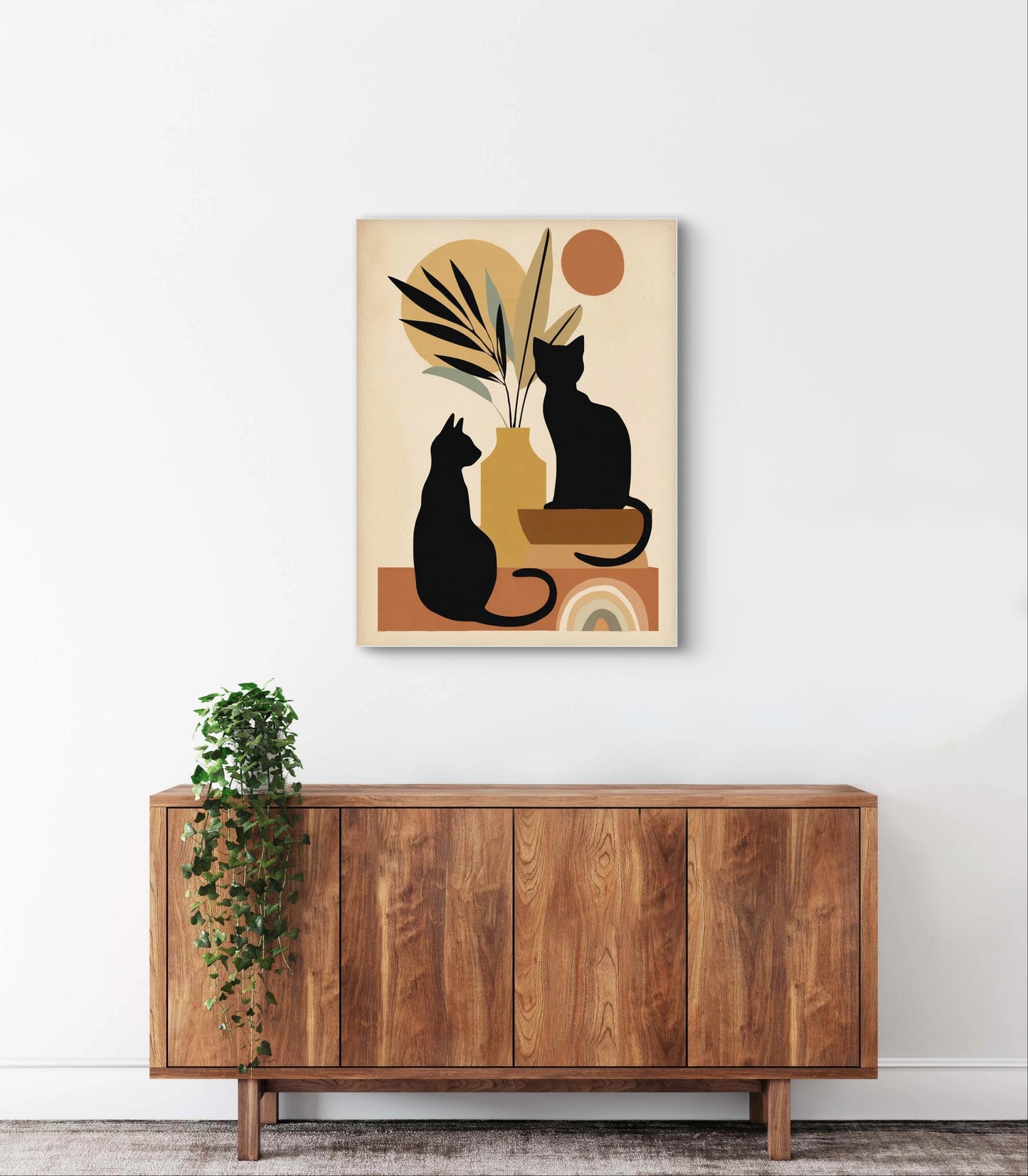 Textielkunstwerk met silhouetten van twee zwarte katten in warme aardetinten,