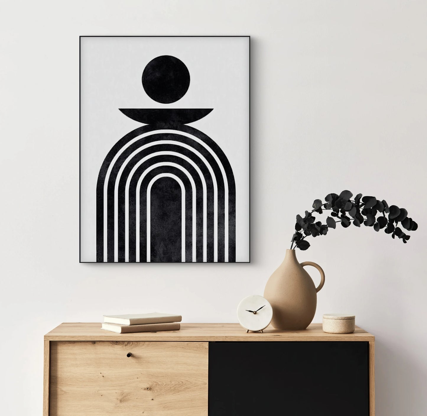 Zwart-wit textielkunstwerk met grafische lijnen en cirkelvorm, hangend boven een houten kast in een minimalistisch interieur
