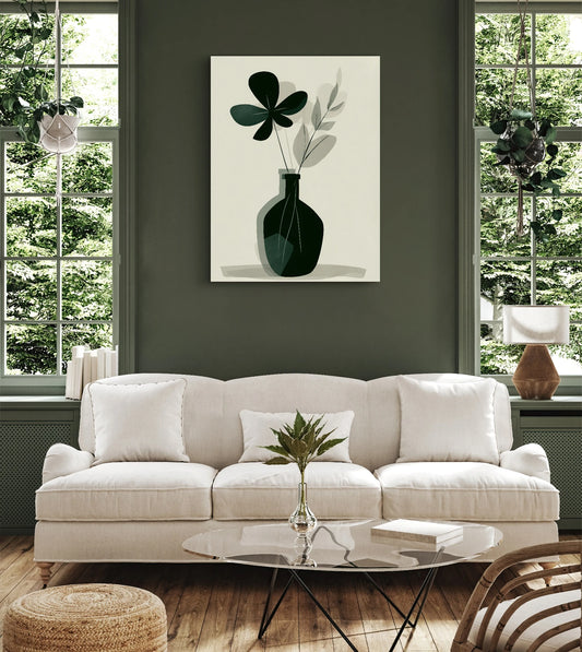 Textielkunstwerk met donkergroene vaas en abstracte bladeren, hangend boven een beige bank in een groen geschilderd interieur
