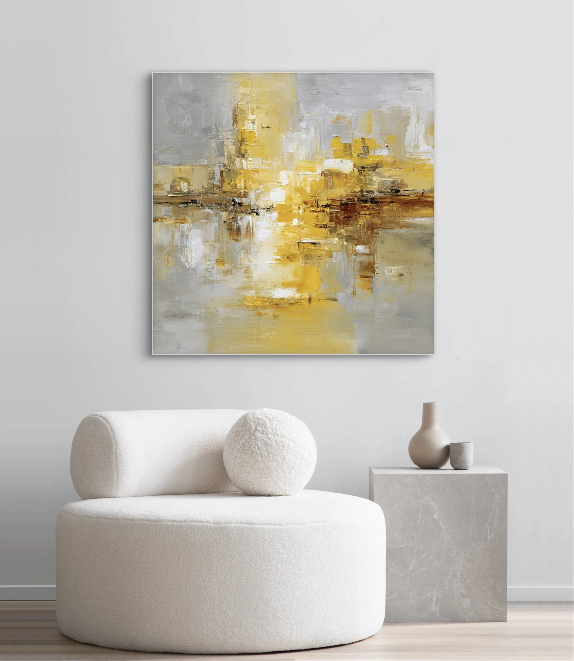 Abstract kunstwerk in goud, grijs en wit tonen boven witte stoel in modern interieur
