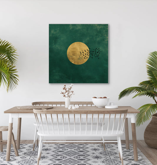 Textielkunstwerk Gouden Vlucht boven een houten eettafel met witte stoelen en groene planten.
