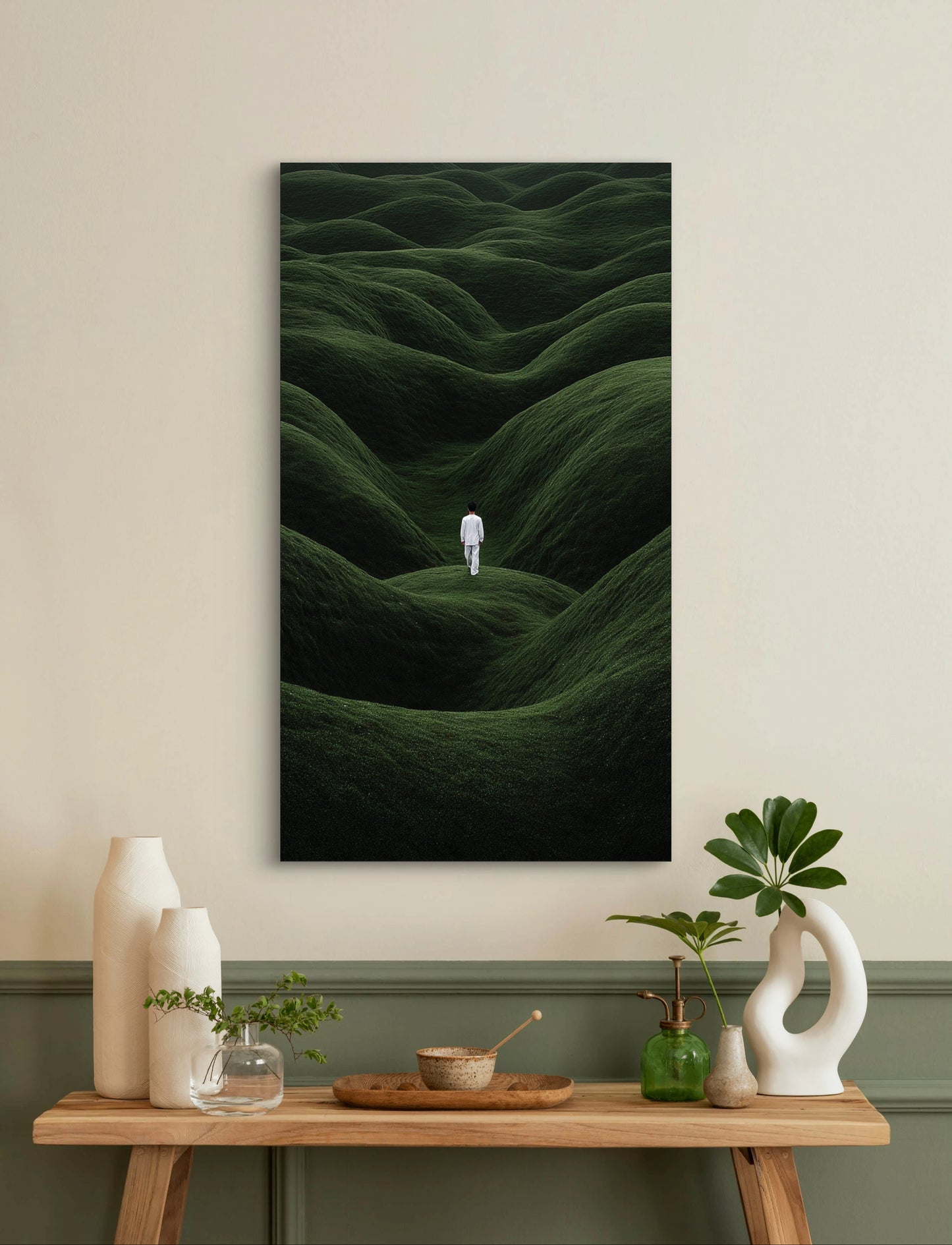 Minimalistisch kunstwerk met persoon in witte kleding tussen groene heuvels aan de muur boven een houten tafel
