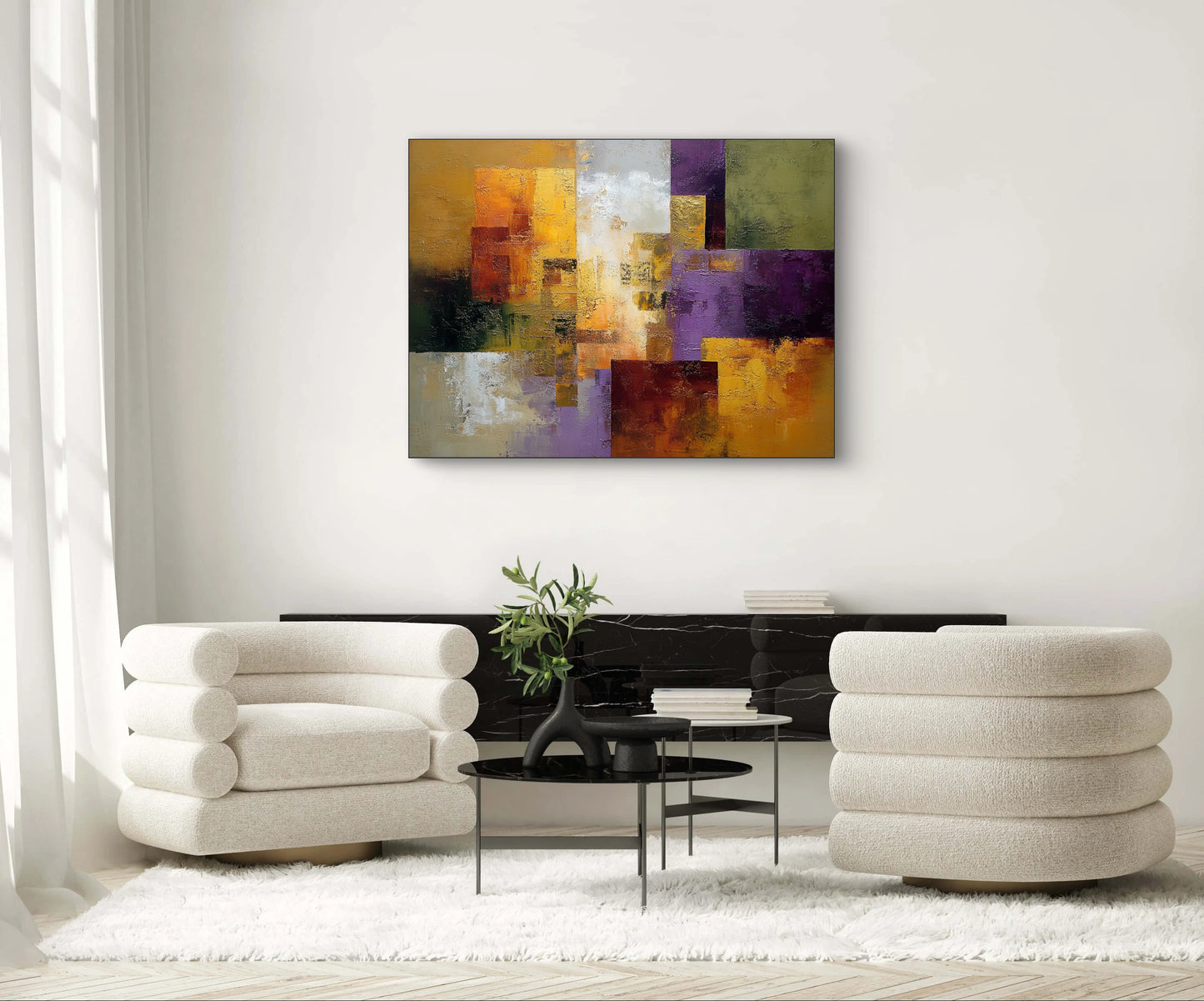 Abstract kunstwerk in goud, paars, rood en groen tonen boven moderne zithoek met lichte stoelen
