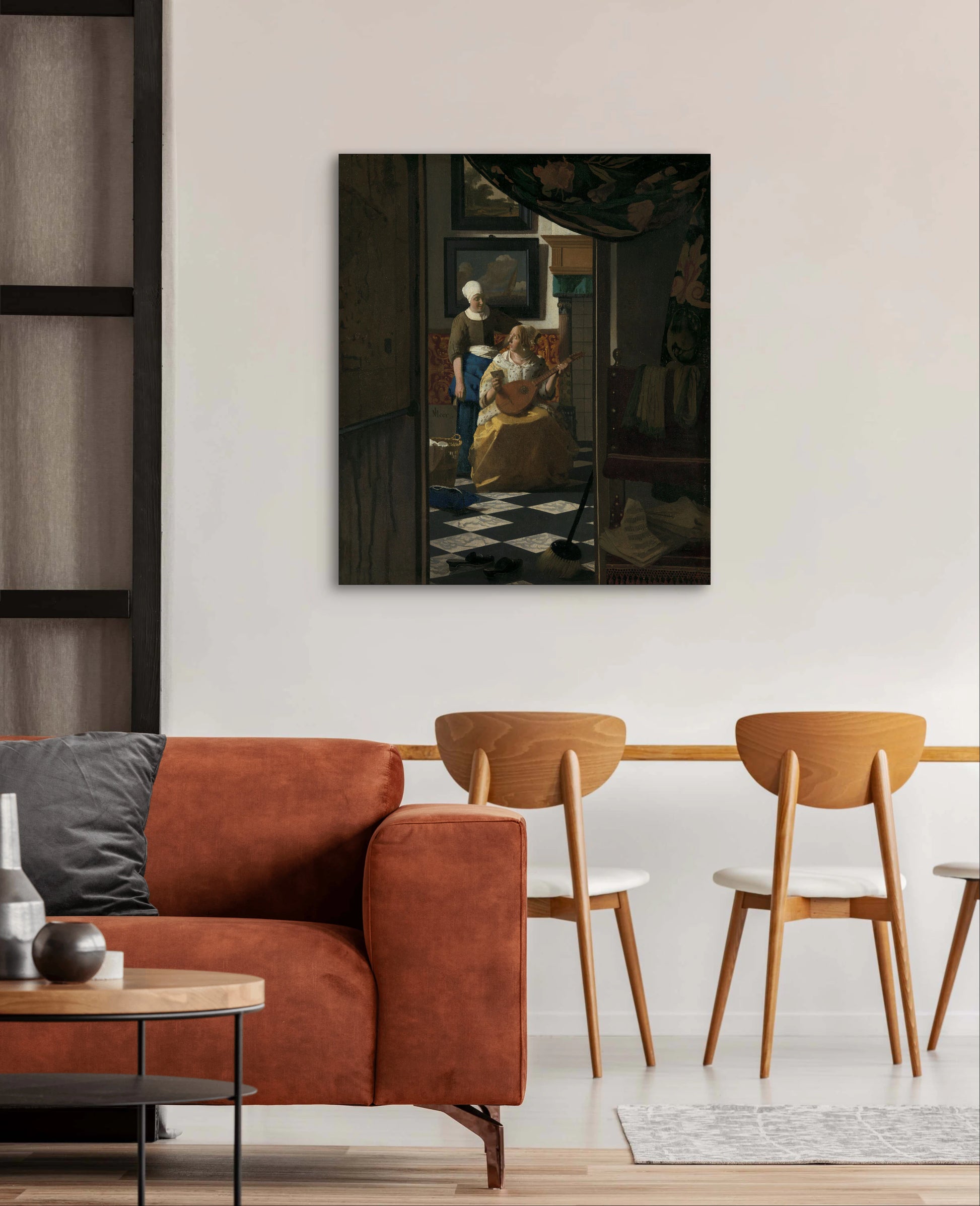 De liefdesbrief van Vermeer boven een warme roestkleurige bank met houten stoelen en minimalistisch interieur