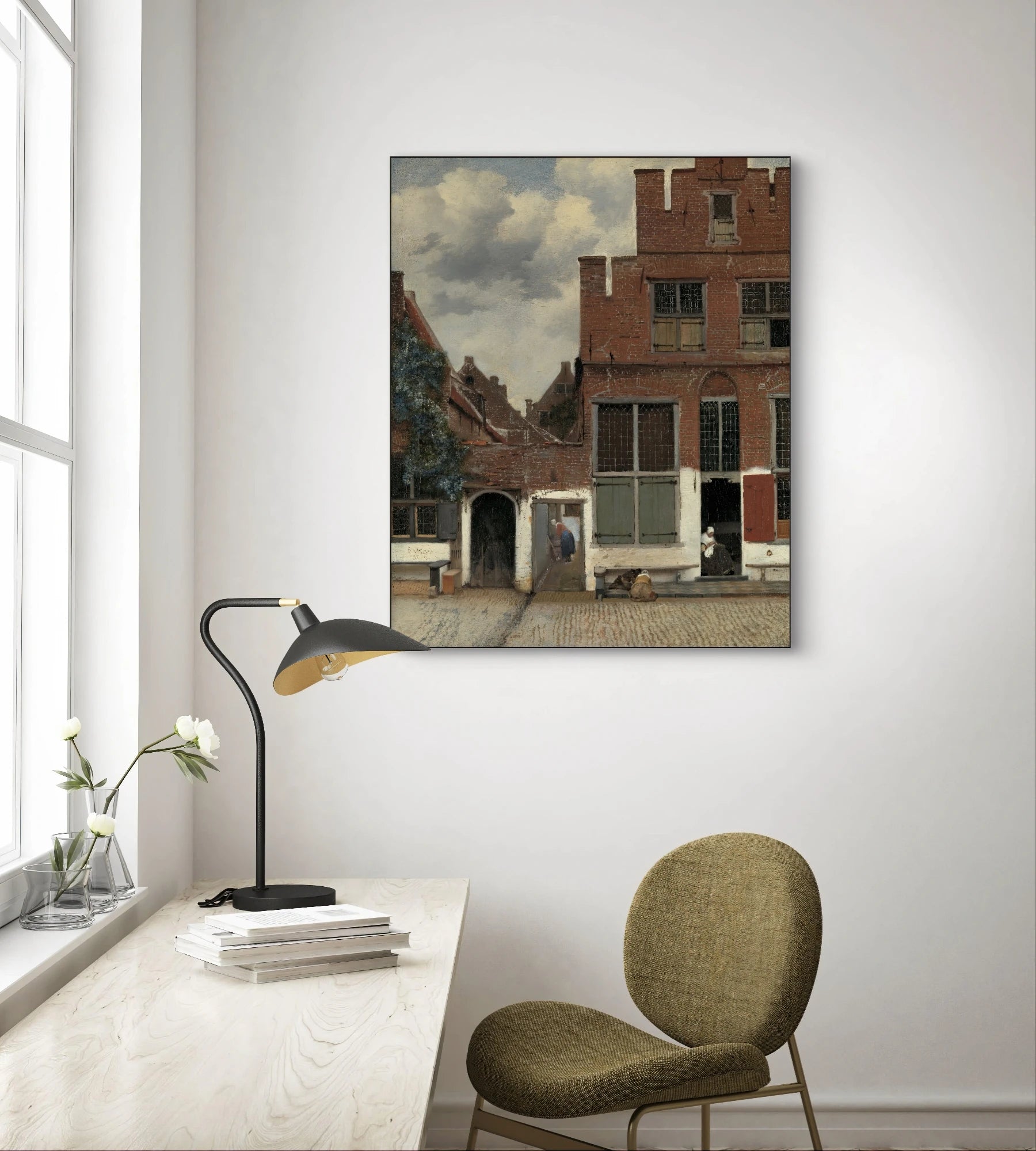 Het straatje van Vermeer boven een houten bureau met olijfgroene stoel en zwarte lamp in een lichte kamer

