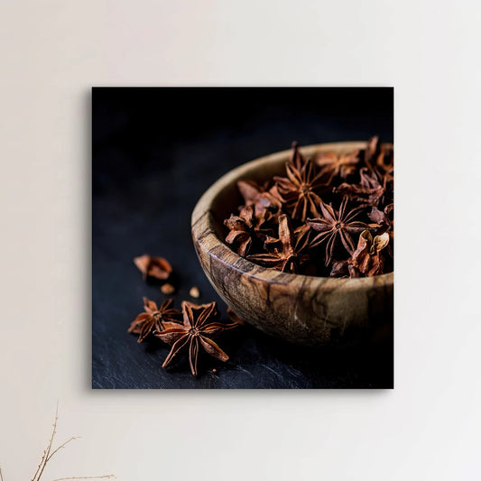 Detail van Kruidenschat met steranijs in een houten kom op donkere achtergrond
