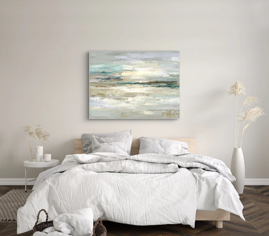 Abstract kunstwerk in zand en turquoise tinten boven bed met witte lakens in rustige slaapkamer
