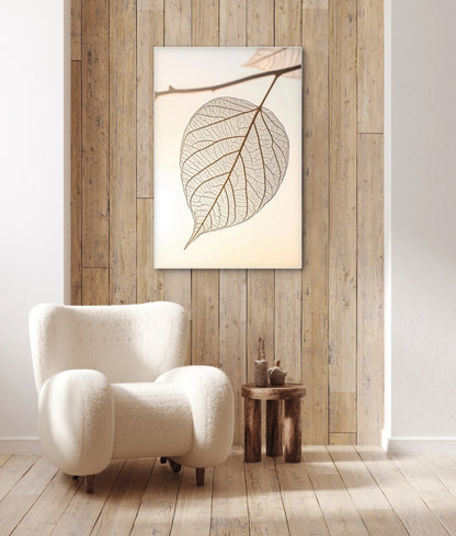 Wandkunst met transparant blad in licht interieur met houten wand en witte fauteuil
