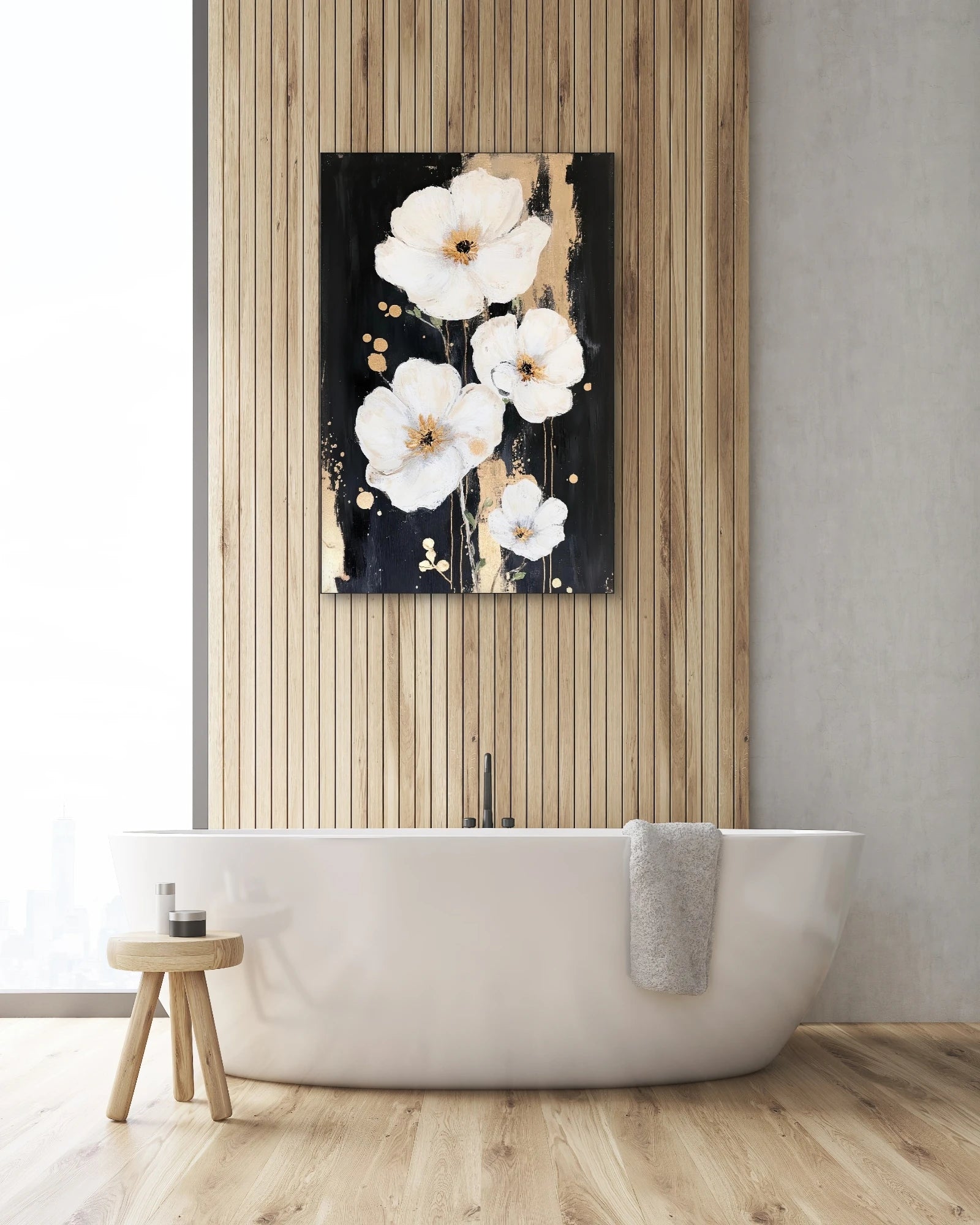 Textielkunstwerk met witte bloemen op zwarte achtergrond met gouden accenten, hangend boven een vrijstaand bad in een lichte badkamer
