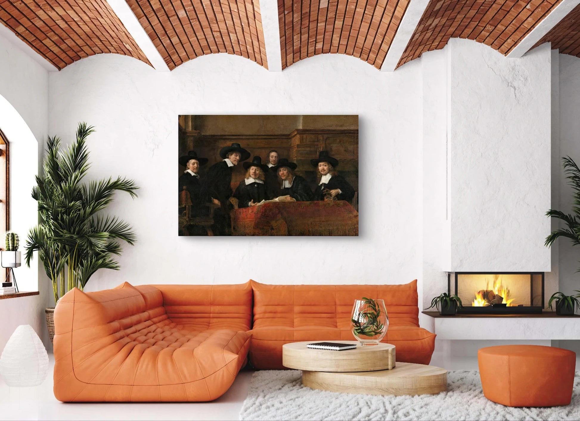 Schilderij “De Staalmeesters” van Rembrandt boven een oranje leren bank in modern interieur met open haard
