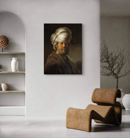 Schilderij “Man in oosterse kleding” van Rembrandt boven modern interieur met bruine designstoel en decoratie in aardetinten
