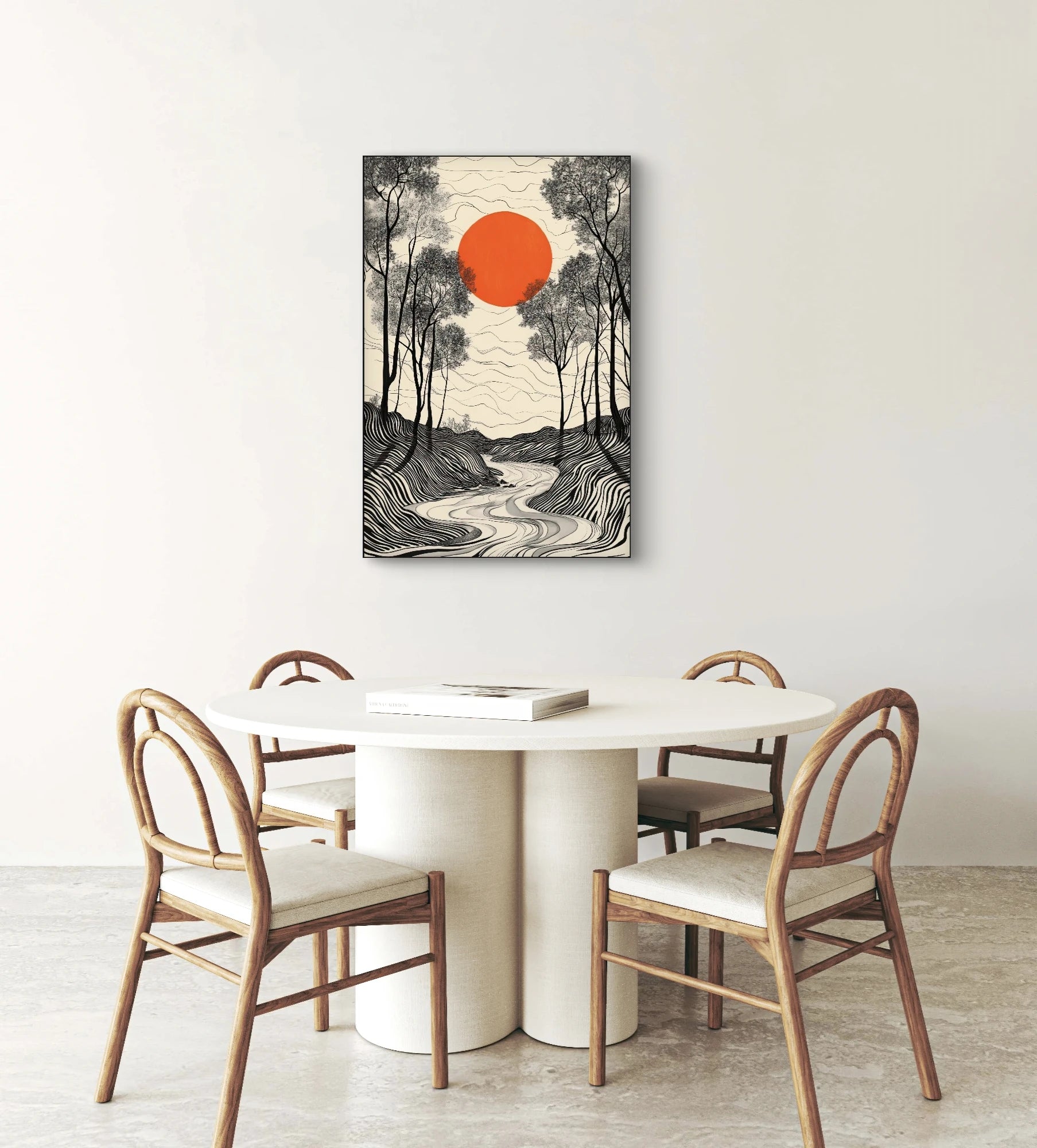 Textielkunstwerk met rode zon en gestileerd zwart-wit landschap, hangend boven een ronde eettafel met houten stoelen
