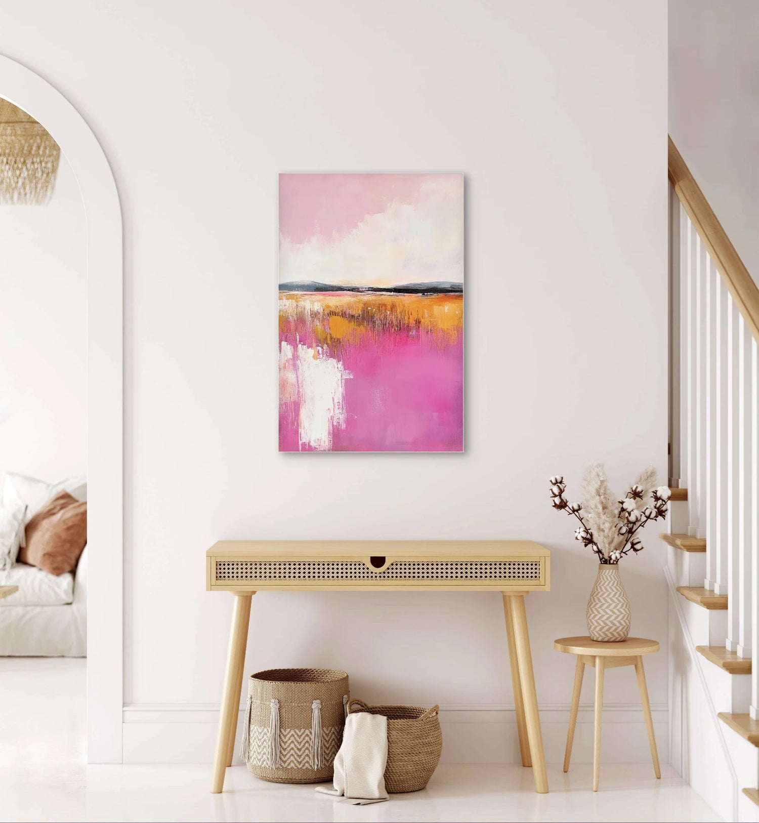 Modern geometrisch schilderij met grafische vlakken in warme en koele kleuren boven een ronde eettafel met houten stoelen
