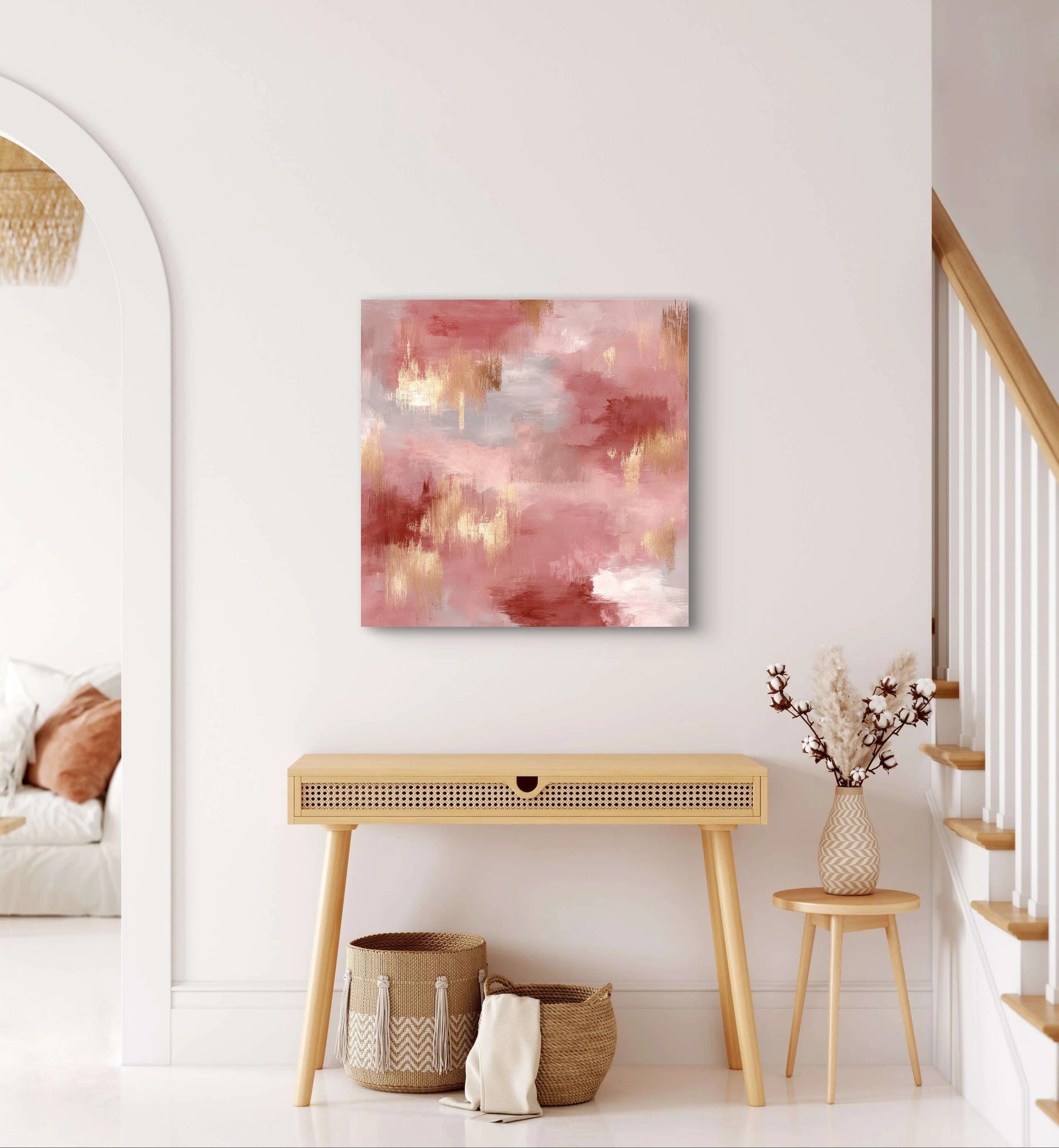 Abstract schilderij Rozennevel in roze en goudtinten boven een houten tafel in een licht interieur
