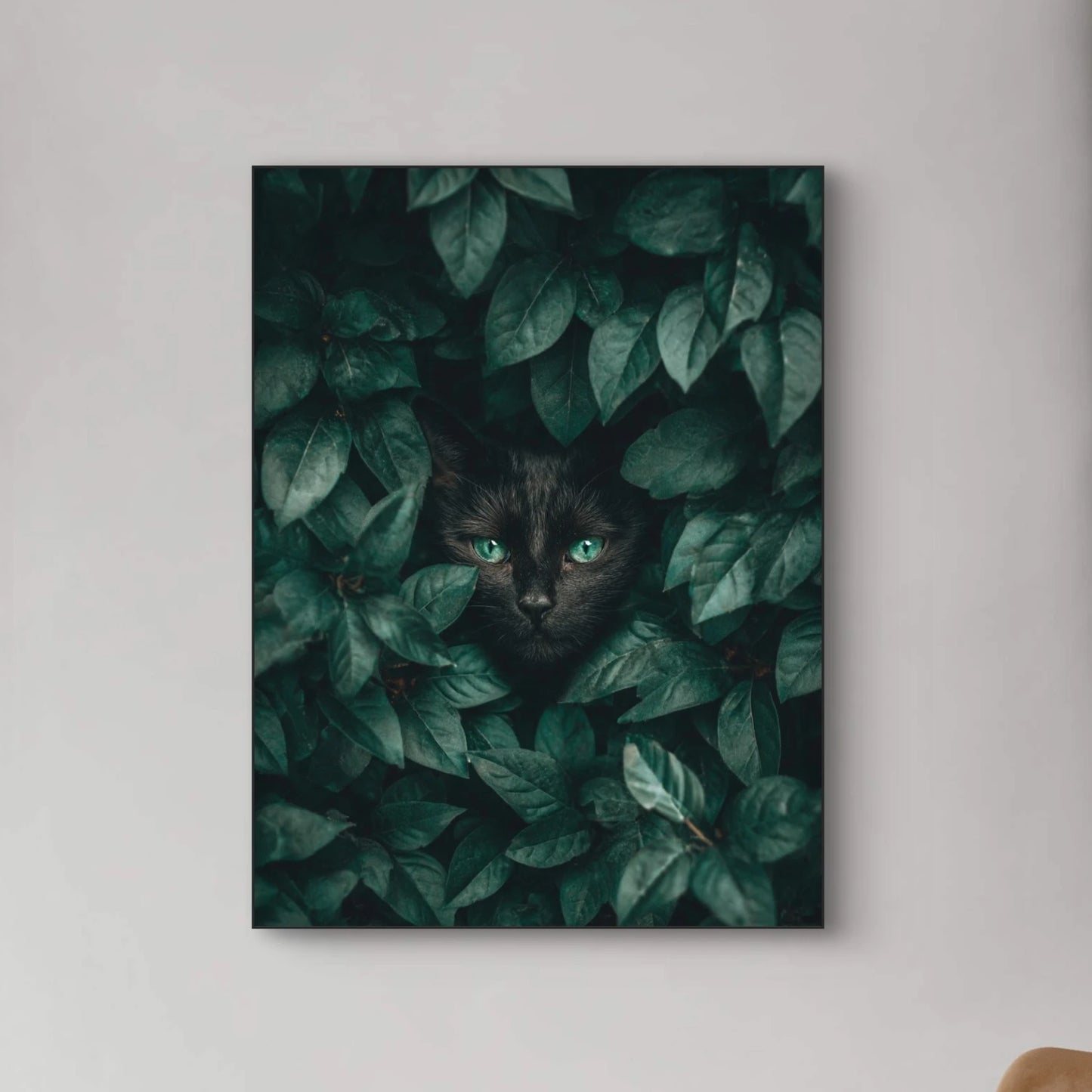 Detailopname van Schaduwblik met zwarte kat en felgroene ogen tussen bladeren  
