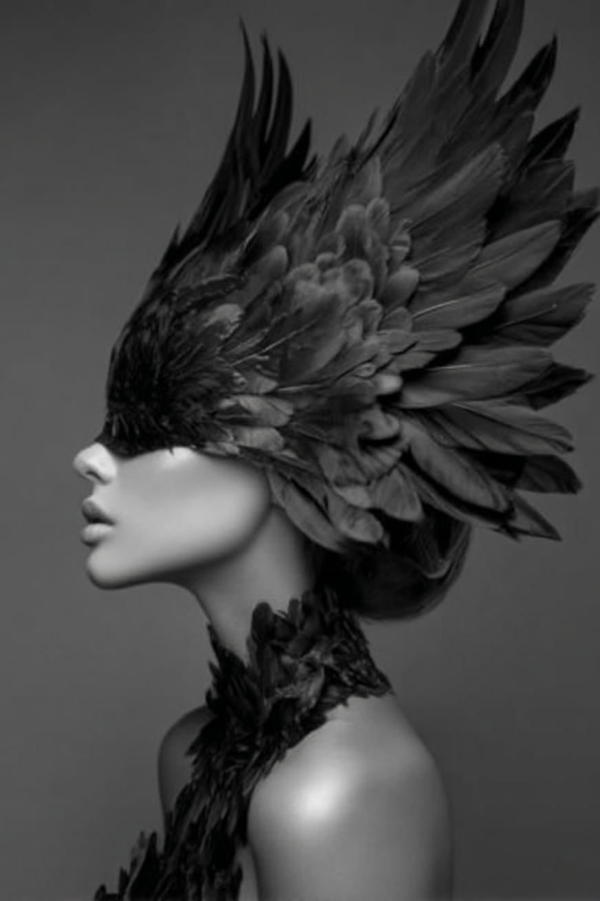 Zwart-wit fotografisch portret van vrouw met verenmasker in elegante pose
