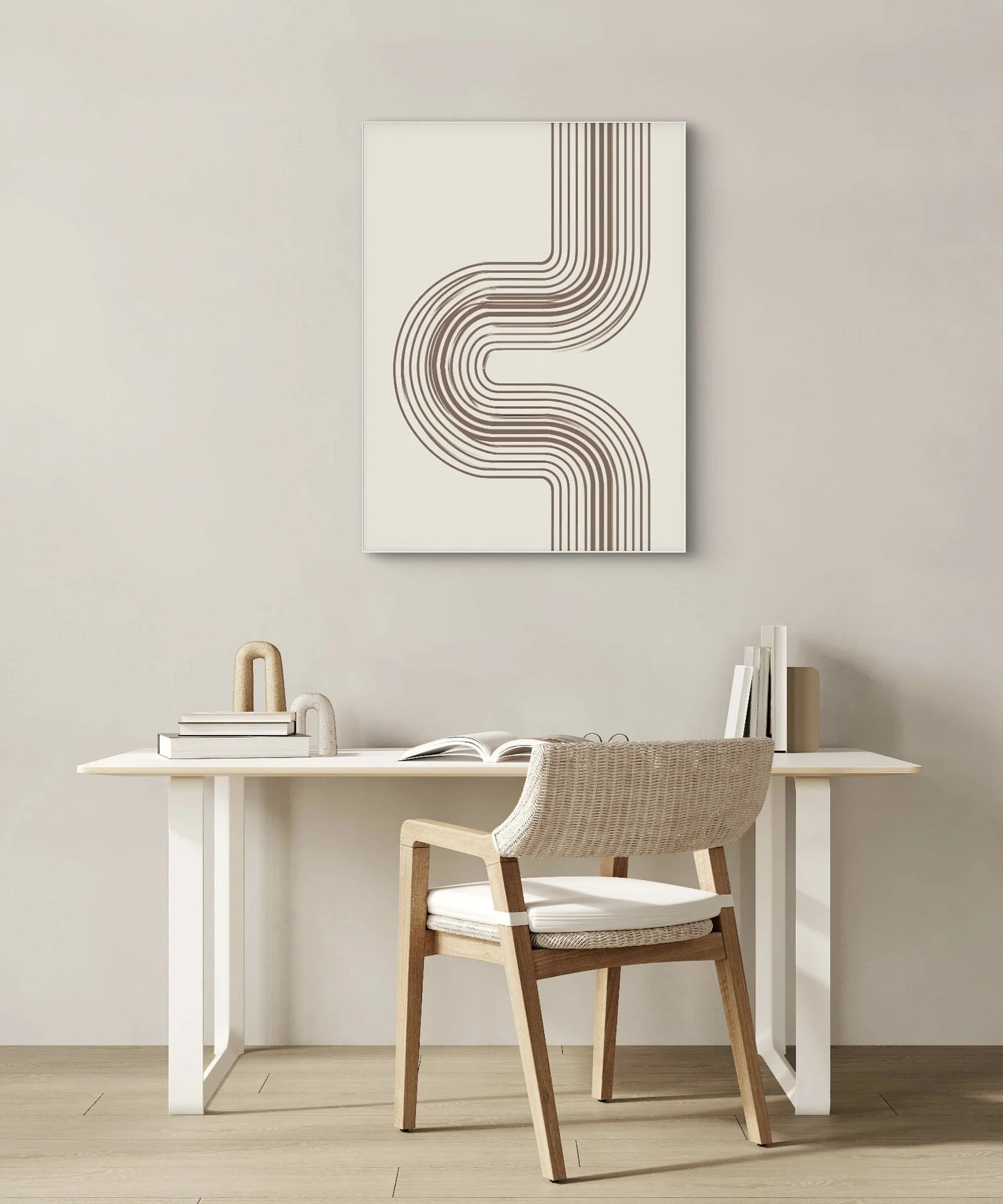 Minimalistisch kunstwerk met gebogen lijnen in bruin aan een lichte muur boven een wit bureau met houten stoel in Scandinavische stijl
