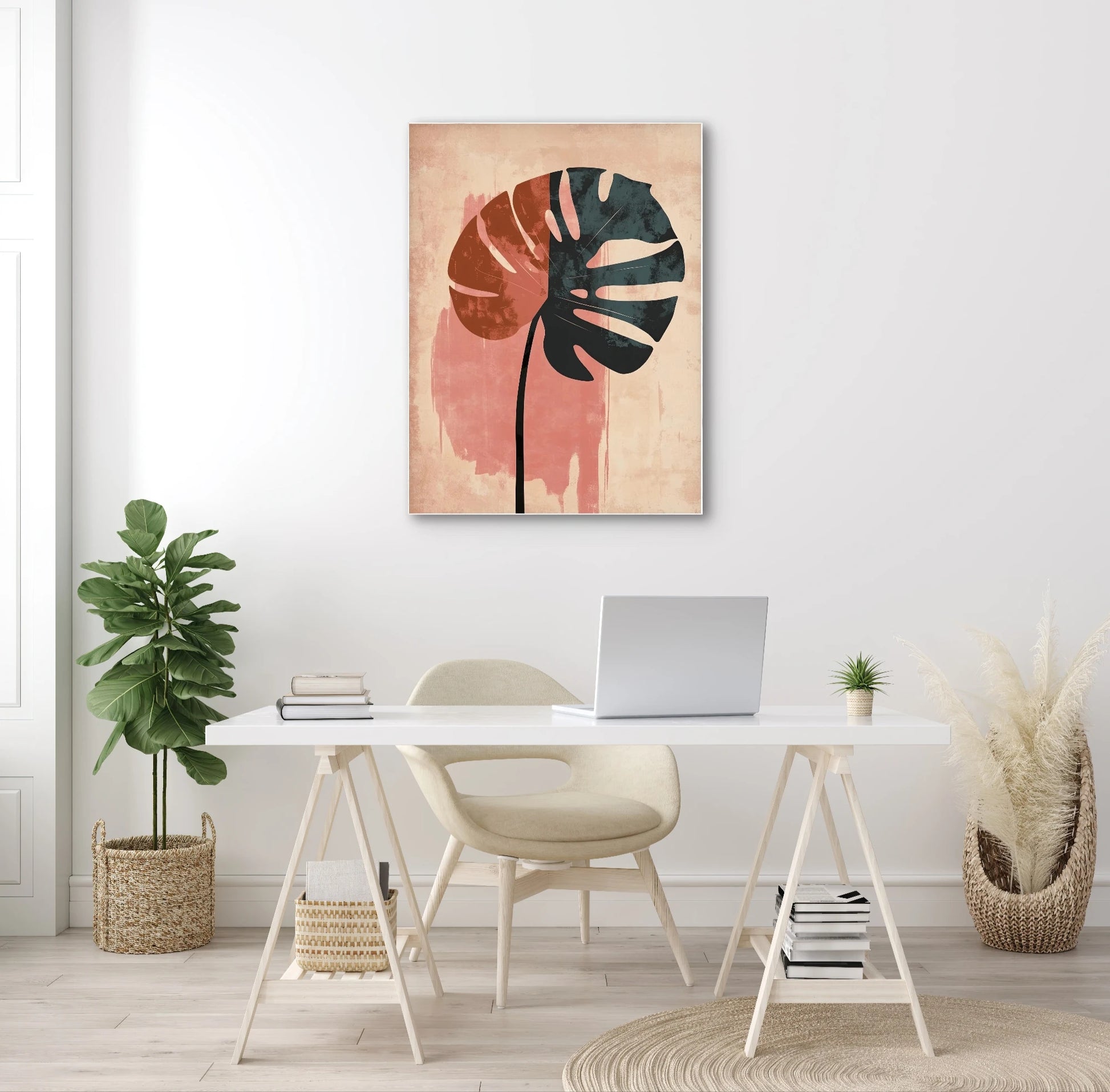 Modern kunstwerk met monstera silhouet in zwart tegen roze achtergrond, aan de muur in een licht interieur met laptoptafel
