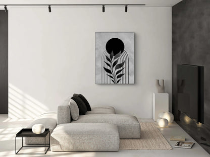 Minimalistisch zwart-wit kunstwerk aan een witte muur boven een lichtgrijze bank in een modern interieur met zwarte accenten
