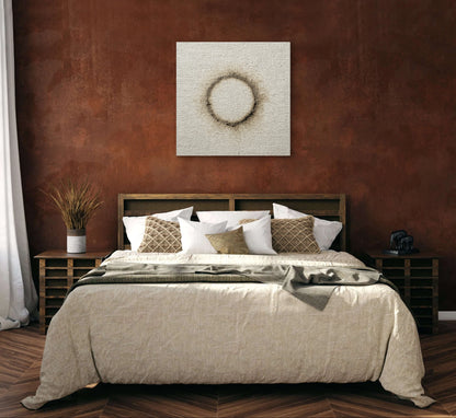 Kunstwerk Verbrand Licht boven een bed met aardetinten in een warme slaapkamer met roestbruine muur.
