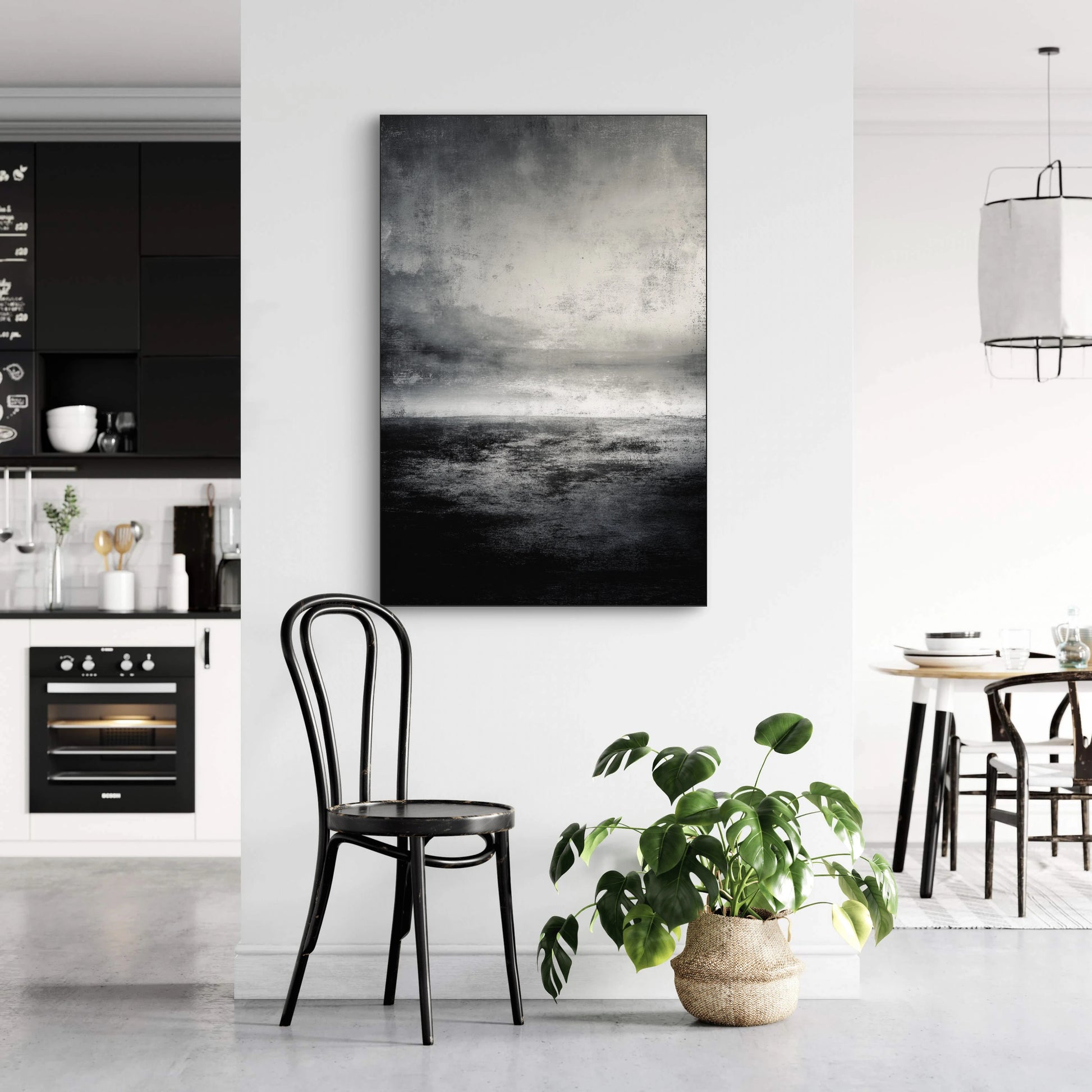 Abstract kunstwerk in zwart en grijs tonen boven zwarte stoel in modern interieur
