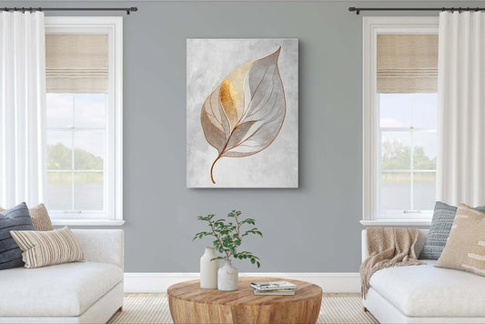 Minimalistisch kunstwerk met goudaccent en bladvorm, aan de muur tussen twee ramen in een lichtgrijze woonkamer
