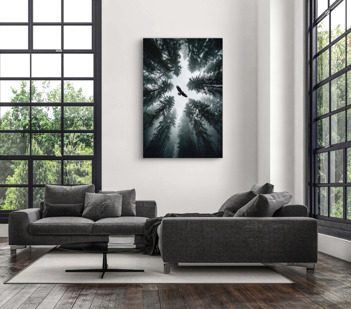 Fotokunstwerk van vogel boven een bos in nevelig licht aan de muur in een modern interieur met grijze bank
