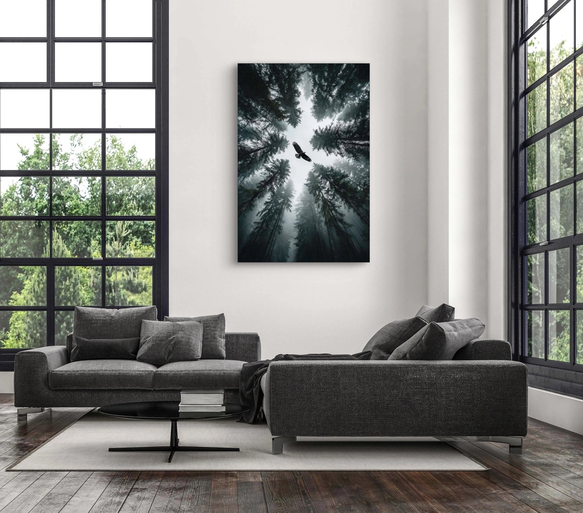 Fotokunstwerk van vogel boven een bos in nevelig licht aan de muur in een modern interieur met grijze bank
