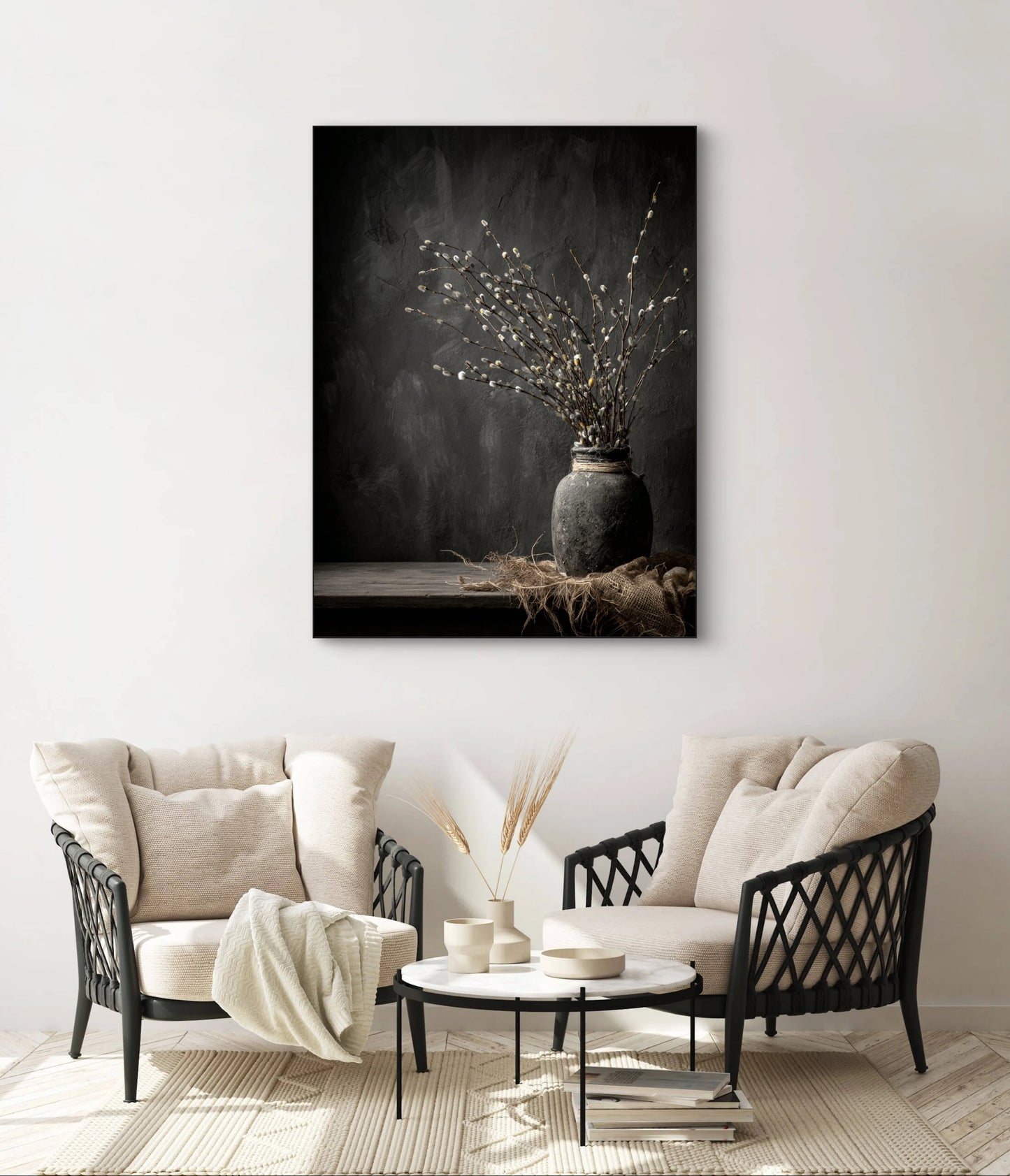 Textielkunstwerk Wekroep van Aarde boven twee beige fauteuils met ronde tafel in een lichte woonkamer.
