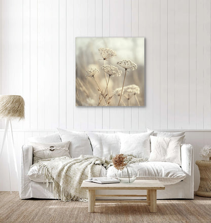 Textielkunstwerk met beige schermbloemen aan de muur in een wit interieur met licht houten accenten
