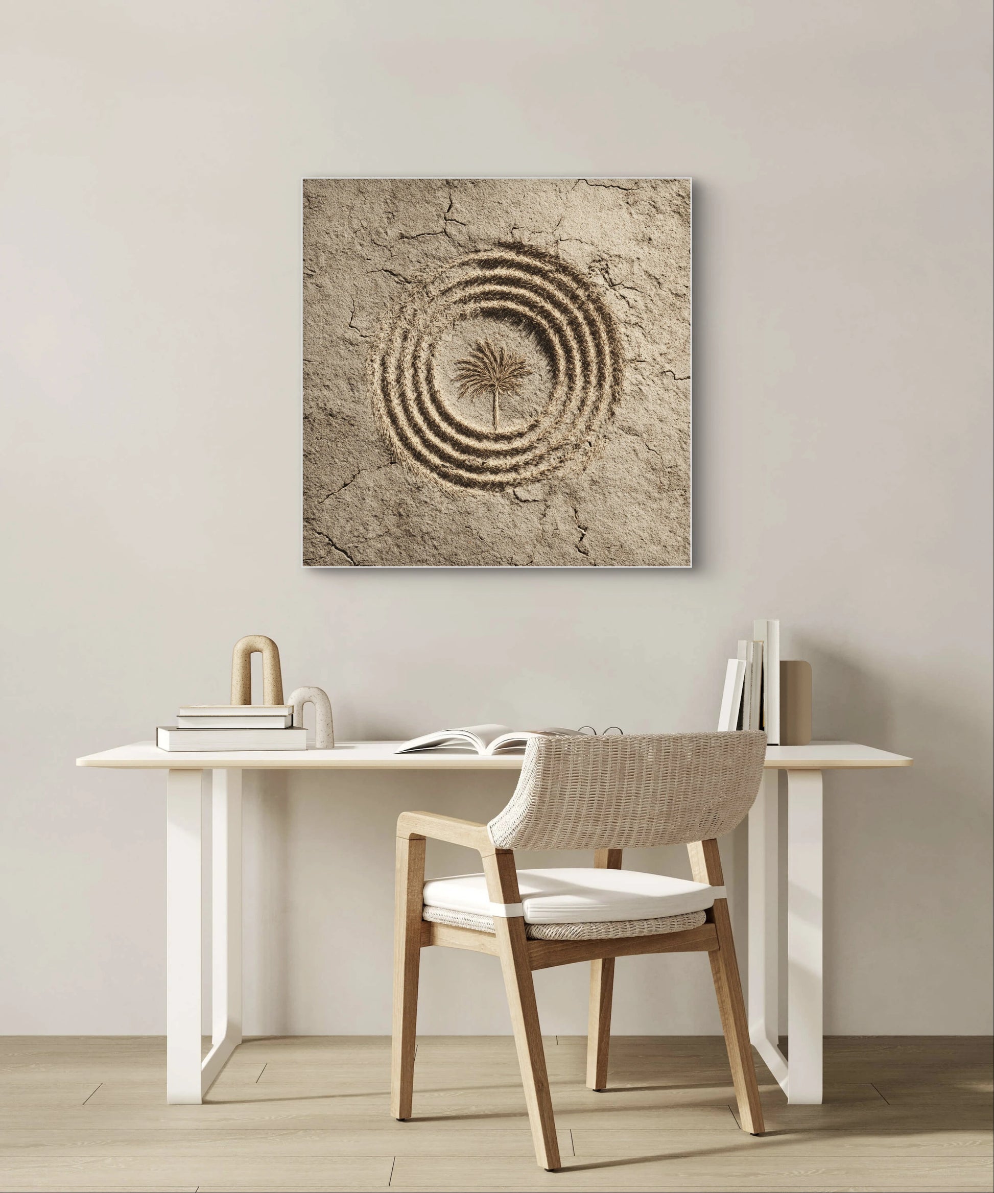 Textielkunstwerk Woestijncirkel boven een wit bureau met houten stoel in een lichte kamer.
