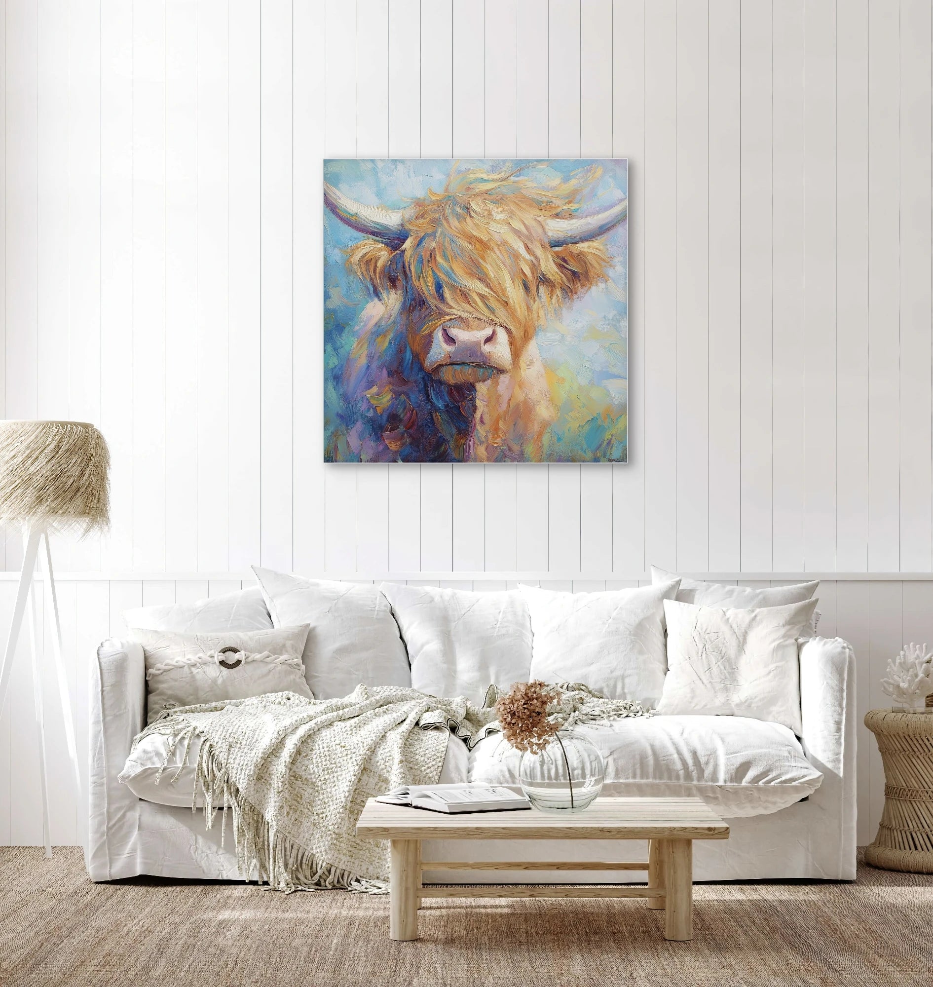 Wandkunst met kleurrijke hooglander in licht interieur met witte bank en houten accenten
