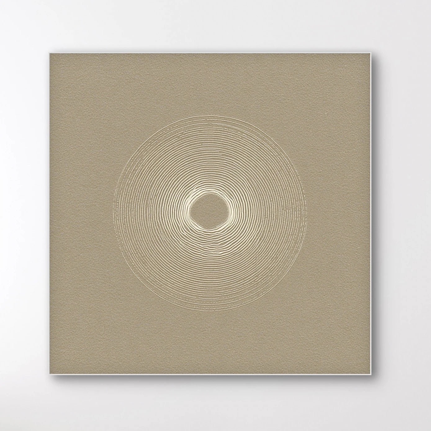 Detail van Zandcirkel met fijne concentrische lijnen op een zandkleurige achtergrond.
