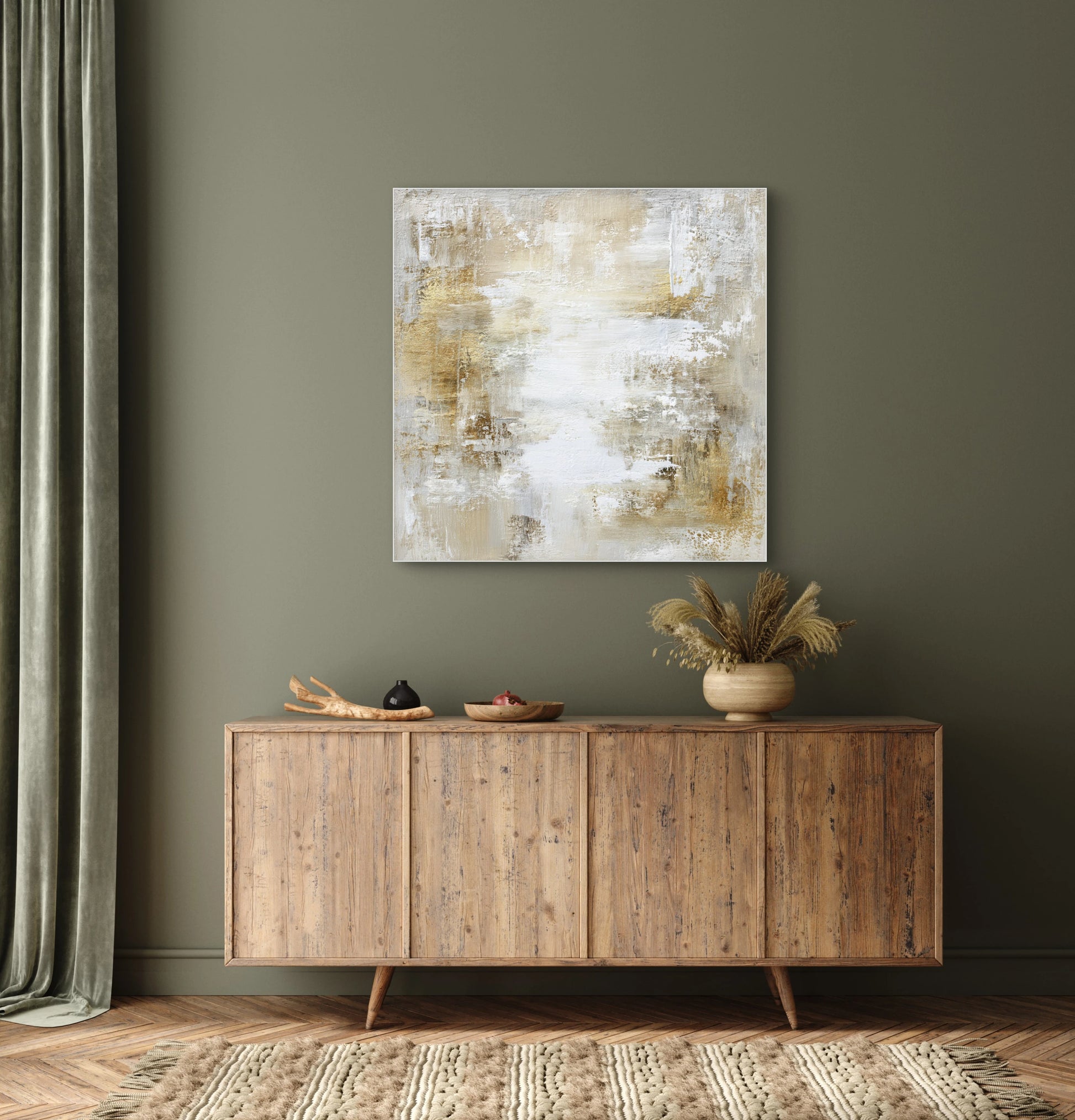 Abstract kunstwerk in zand en goud tonen boven houten dressoir met groene muur
