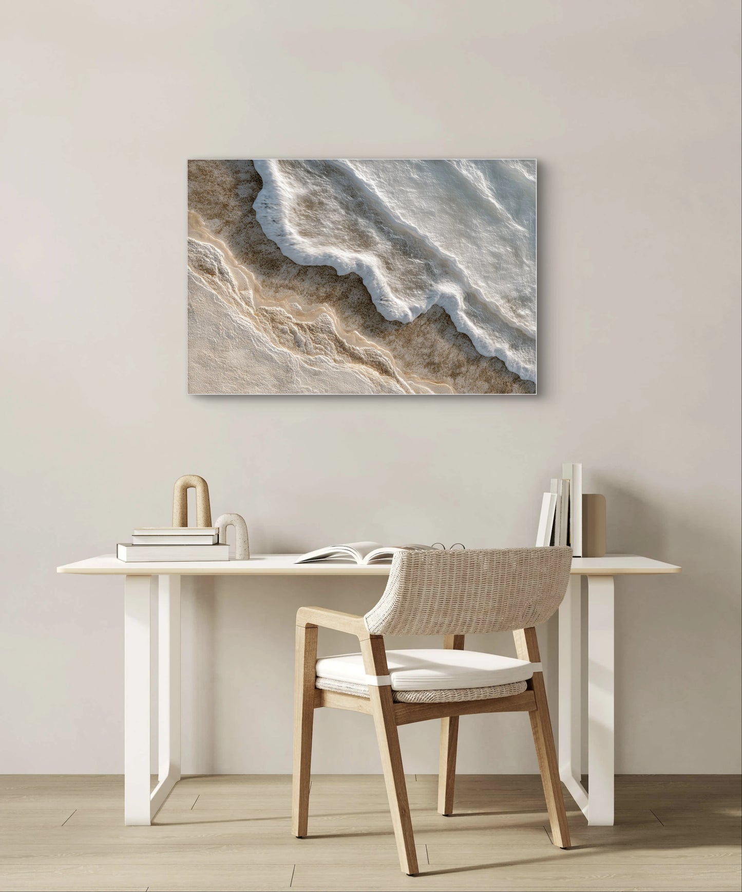 Abstract kunstwerk in wit en beige tinten boven een minimalistisch bureau met houten stoel
