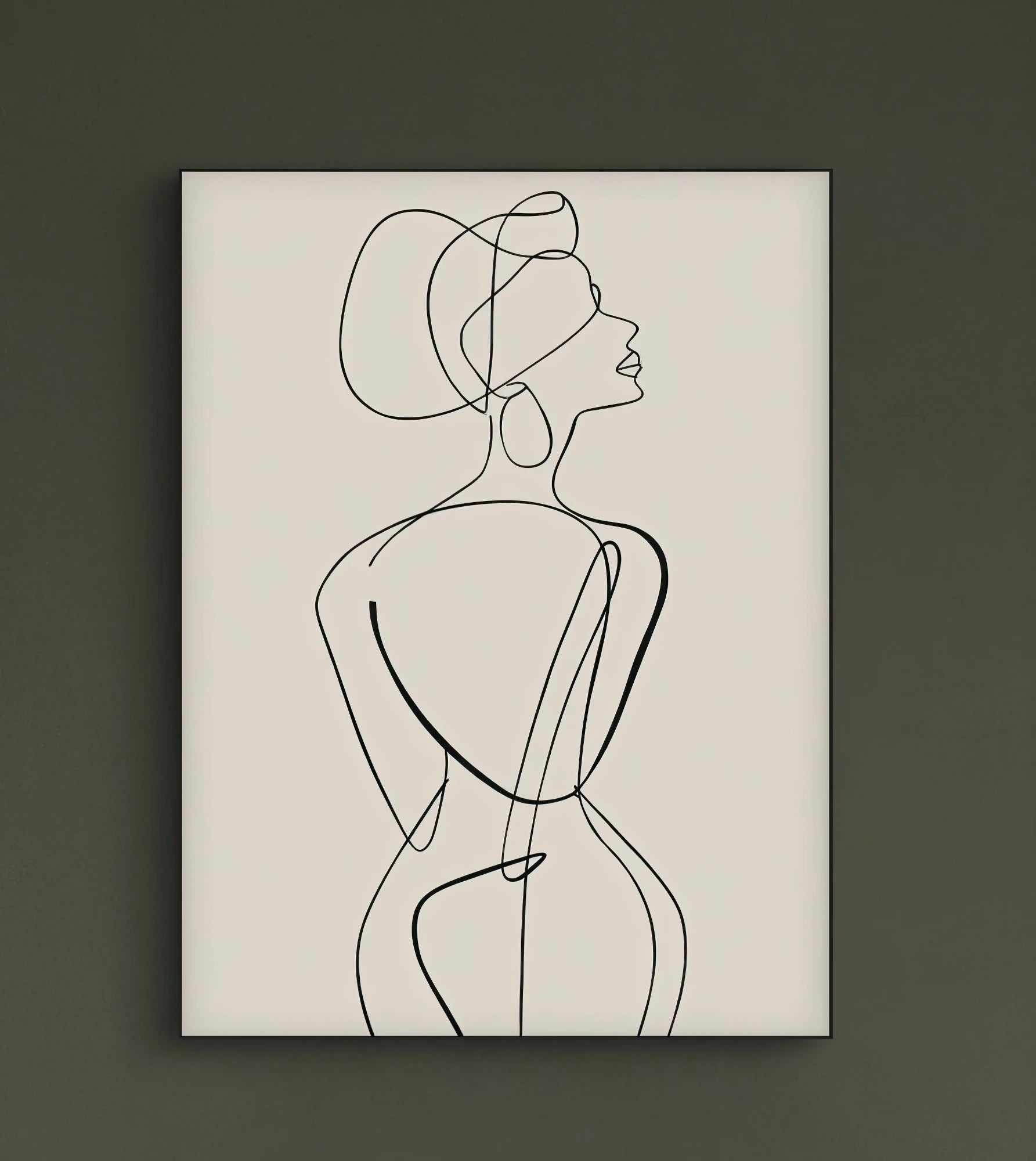 Minimalistisch lijnkunstwerk van een vrouw aan een donkergroene muur boven een lichtbeige bank in een sfeervol interieur met planten
