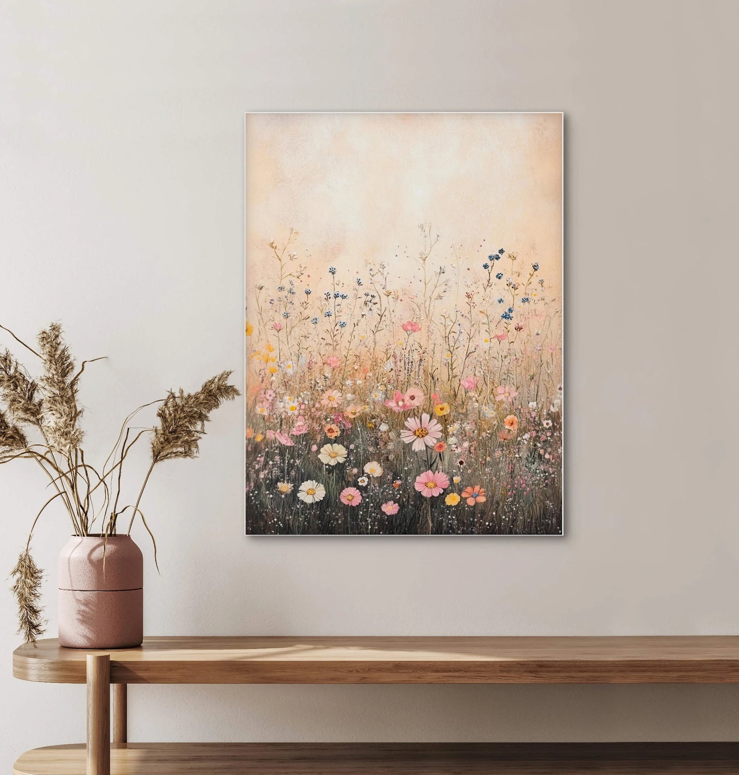 Textielkunstwerk met kleurrijk bloemenveld aan de muur boven een houten plank in een naturel interieur
