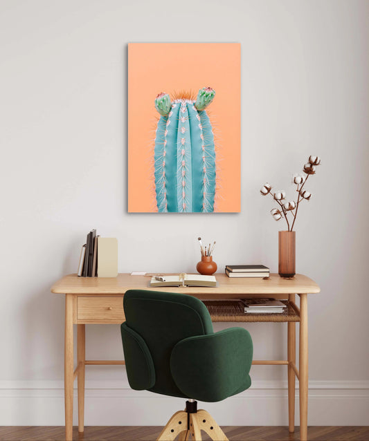 Textielkunstwerk van een blauwe cactus met bloemen aan de muur boven een houten bureau in warm interieur
