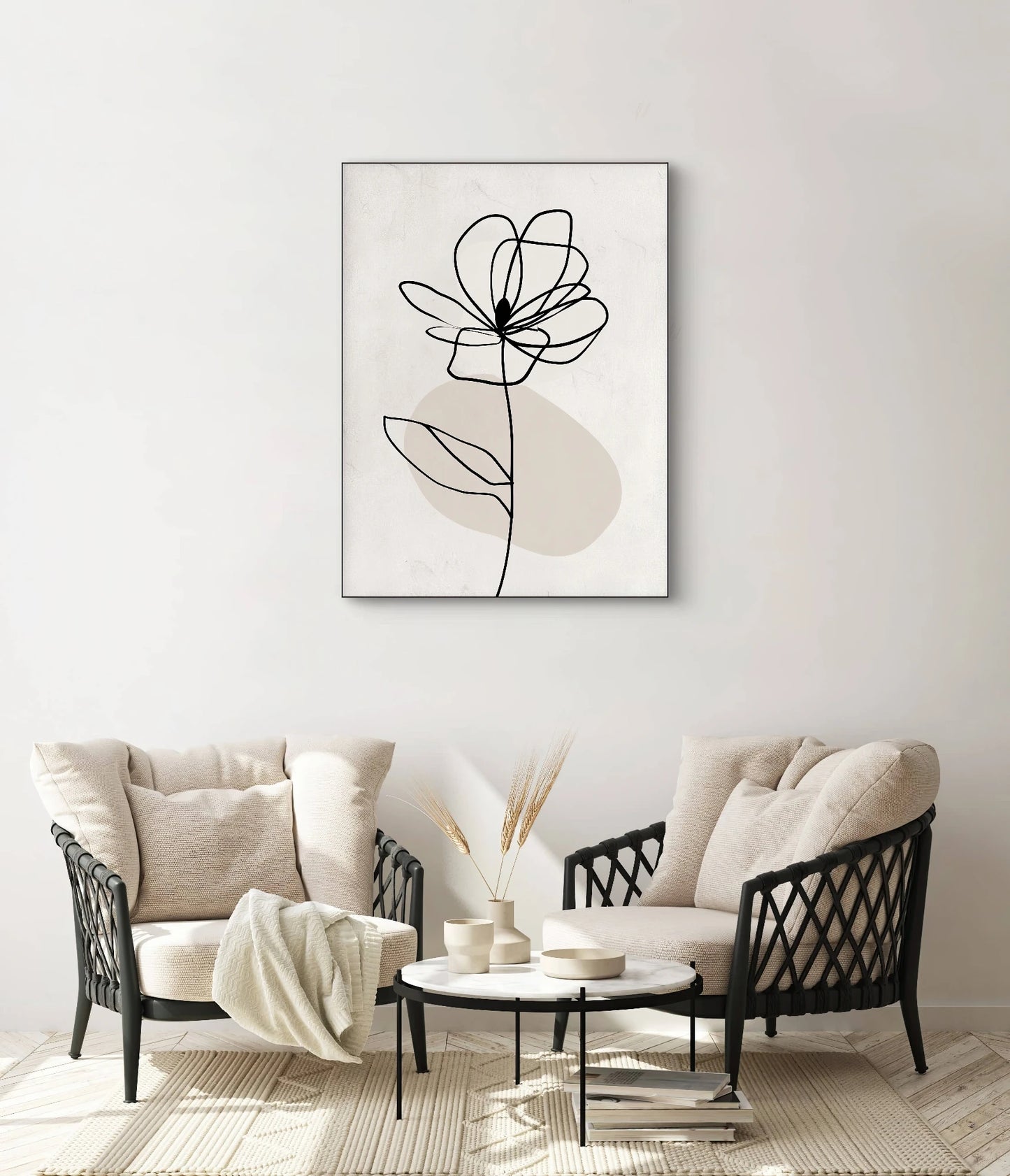 Textielkunstwerk met zwarte lijntekening van bloem op beige achtergrond, hangend boven twee beige fauteuils in een rustgevend interieur
