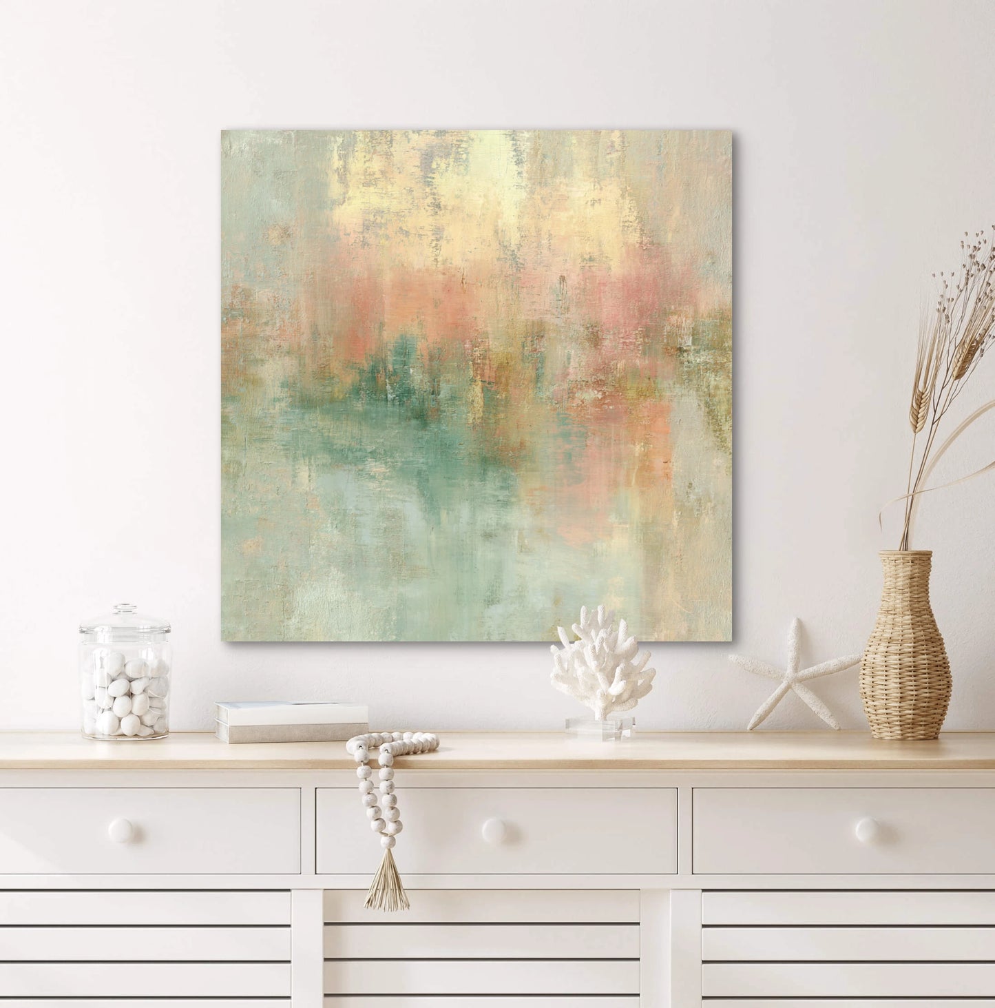 Abstract schilderij Zonvloed met pastelkleuren boven een lichte houten kast met stranddecoratie

